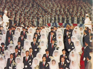 True Parents sprinkle holy water on the couples